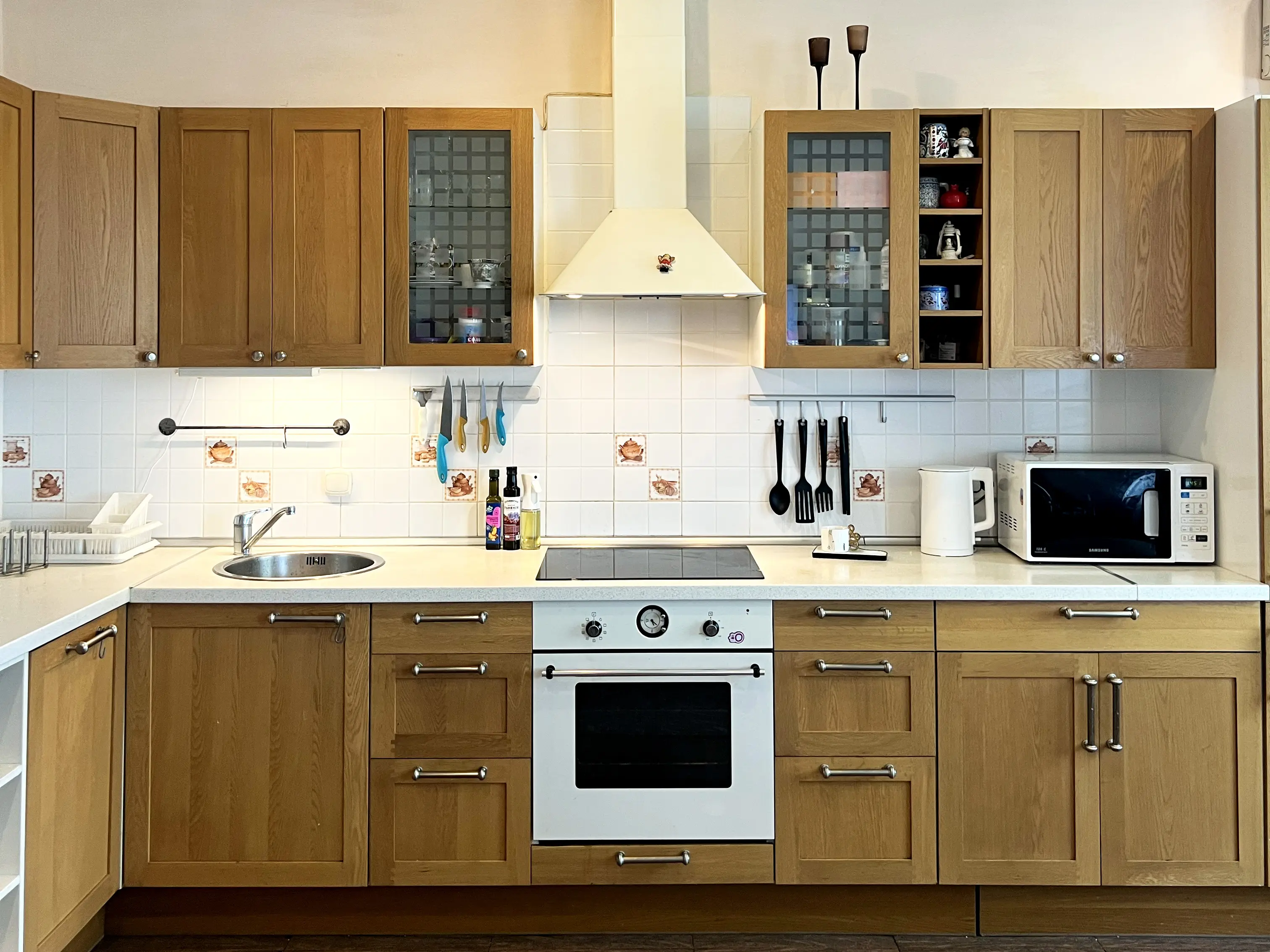 Кухня совмещена с гостиной. На кухне варочная панель, духовка, микроволновка, чайник и посудомойка