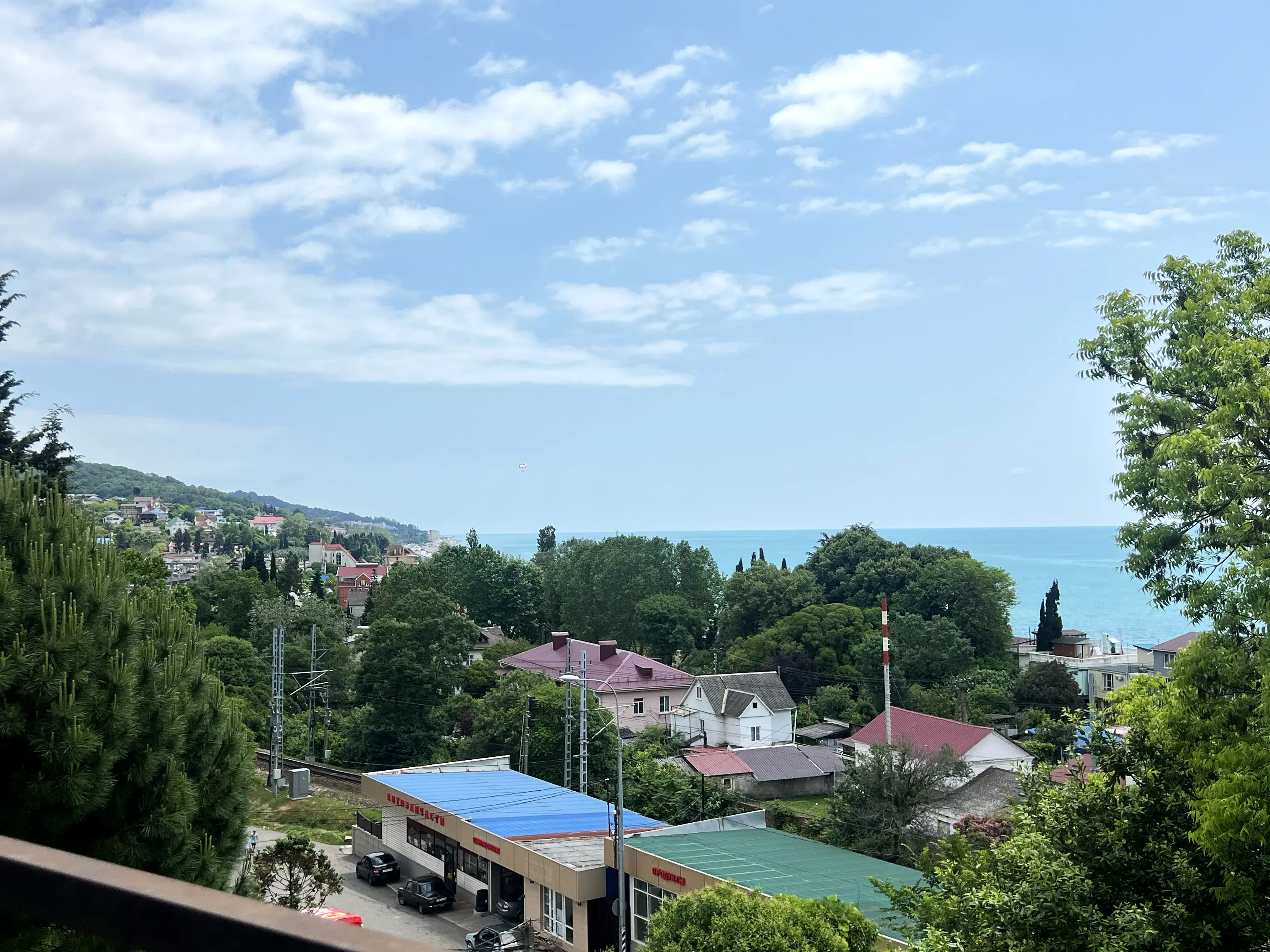 С балкона открывается вид на посёлок и море, внизу вид на сад и бассейн